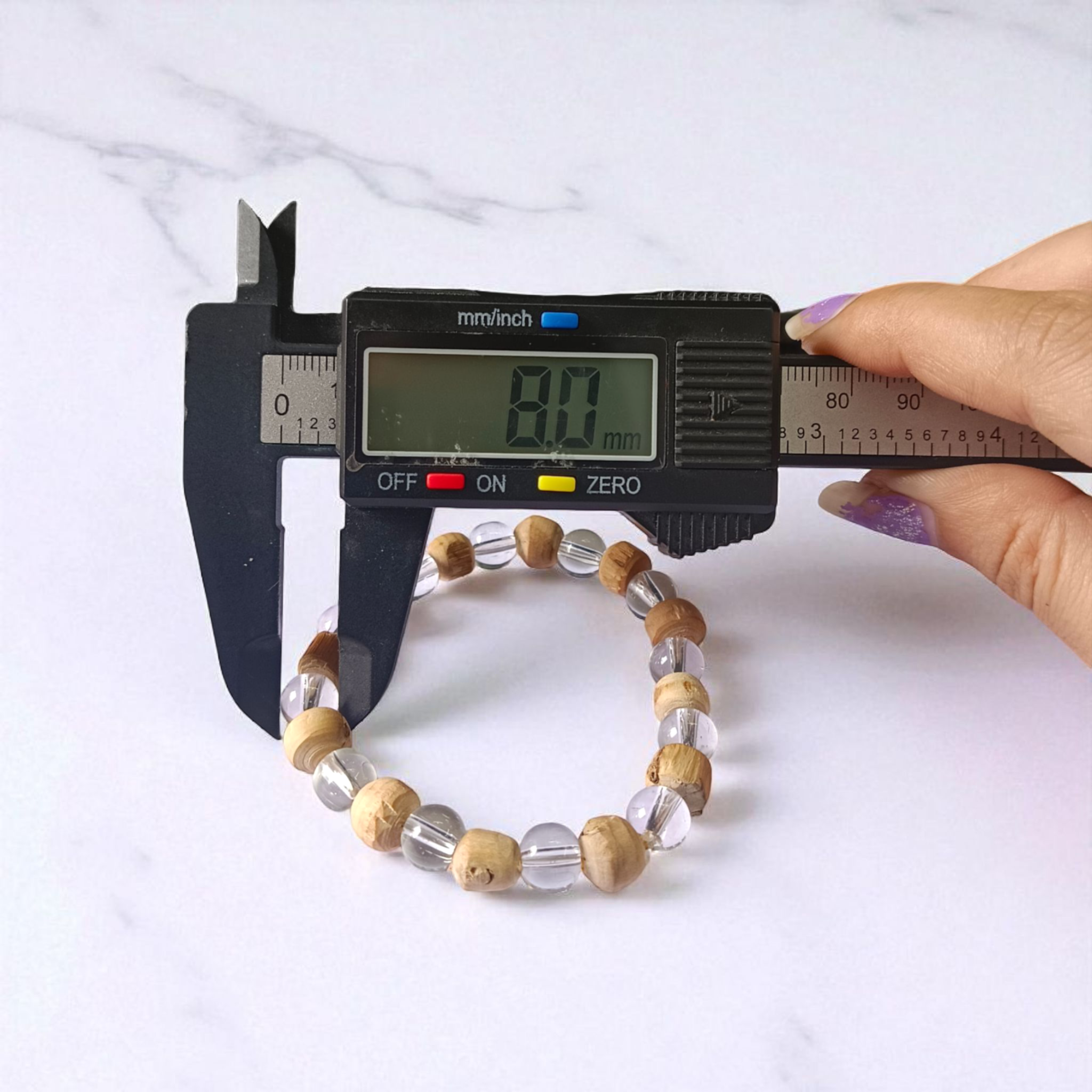 A stretchable 8mm beaded bracelet made from natural Tulsi and Sphatik crystals, ideal for spiritual and healing use, placed against a white background