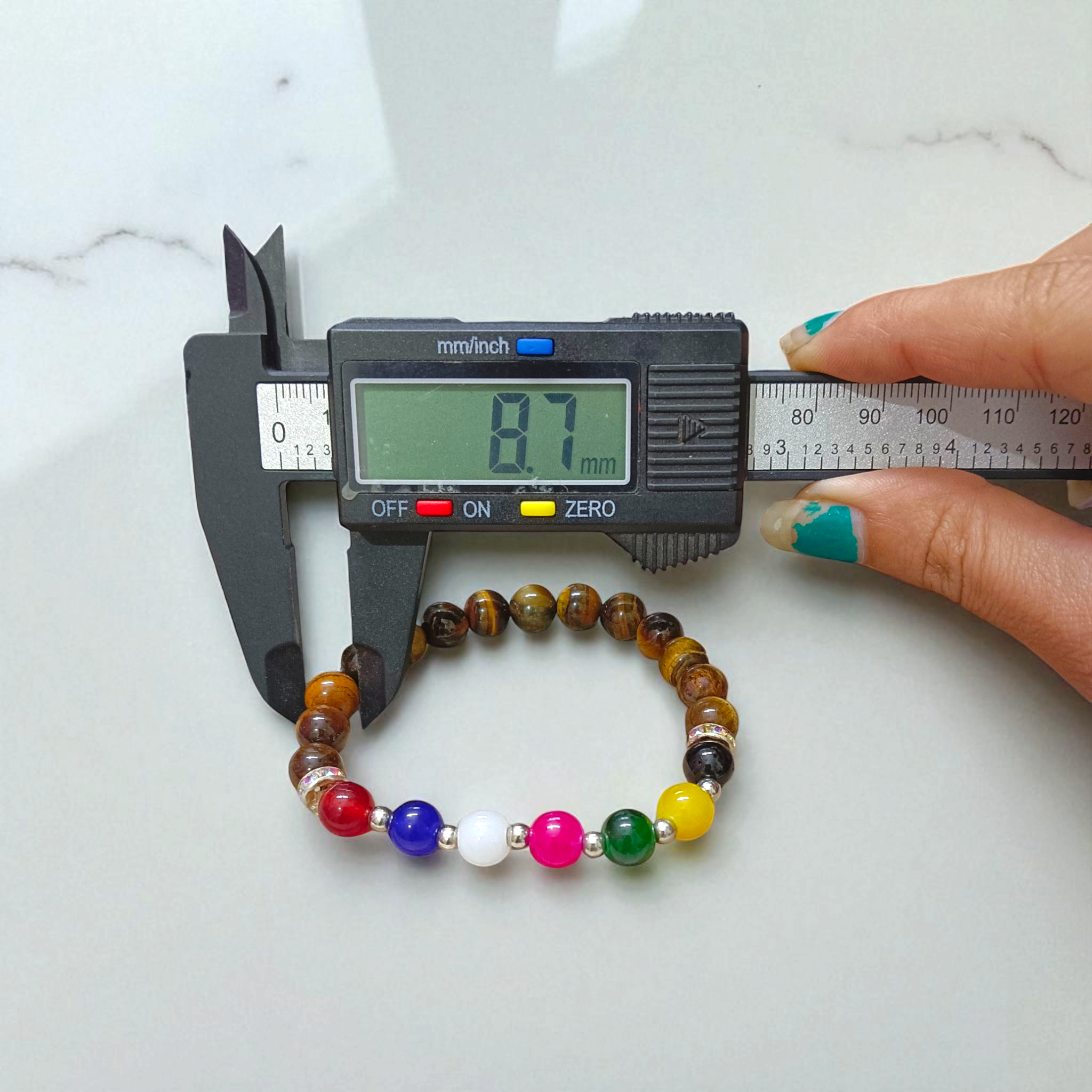 A stretchable bracelet made with 7 types of agate stones (Hakik) and natural Tiger Eye beads, featuring 8mm polished stones—perfect for protection, focus, and healing