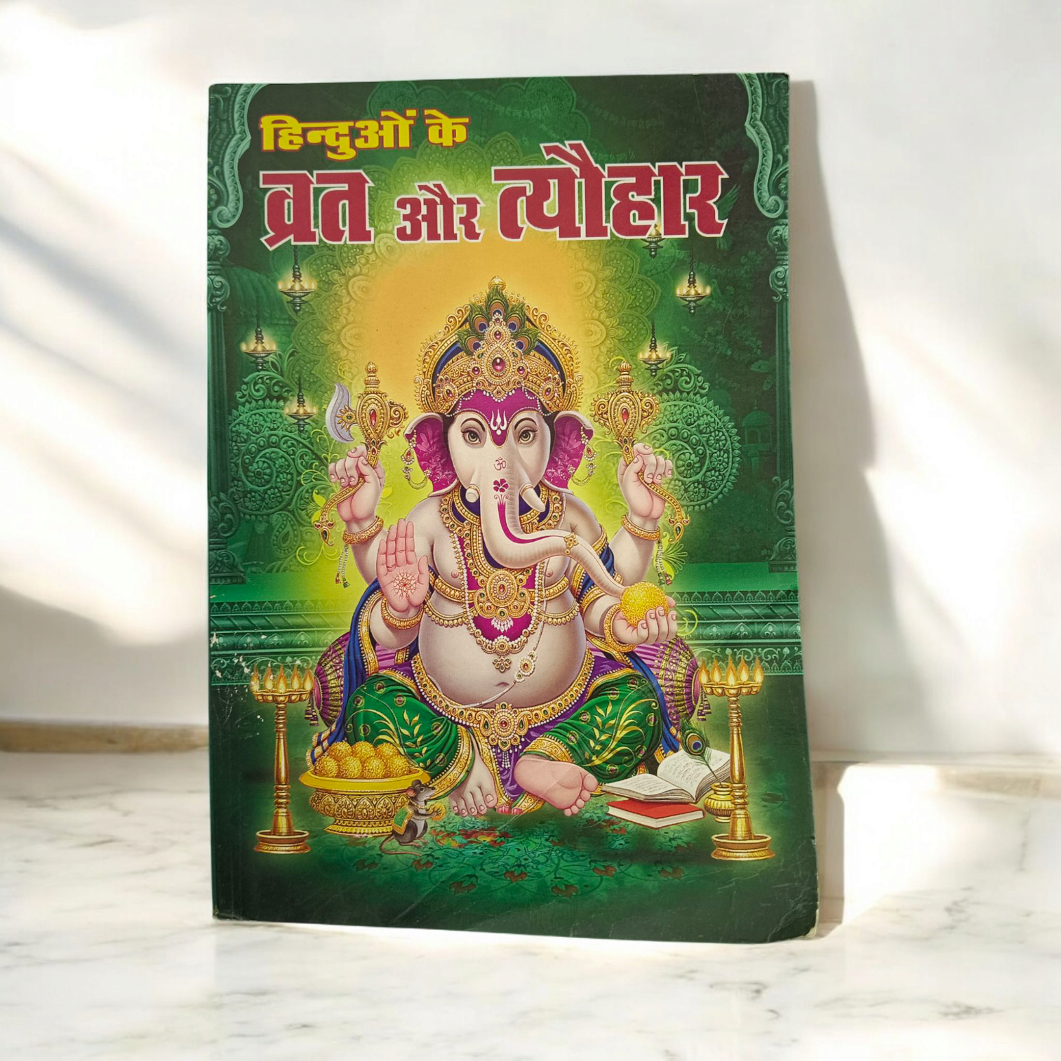 An image of the Hinduon ke Vrat Aur Tyohar guidebook, featuring Hindu gods and symbols associated with fasting and festivals.