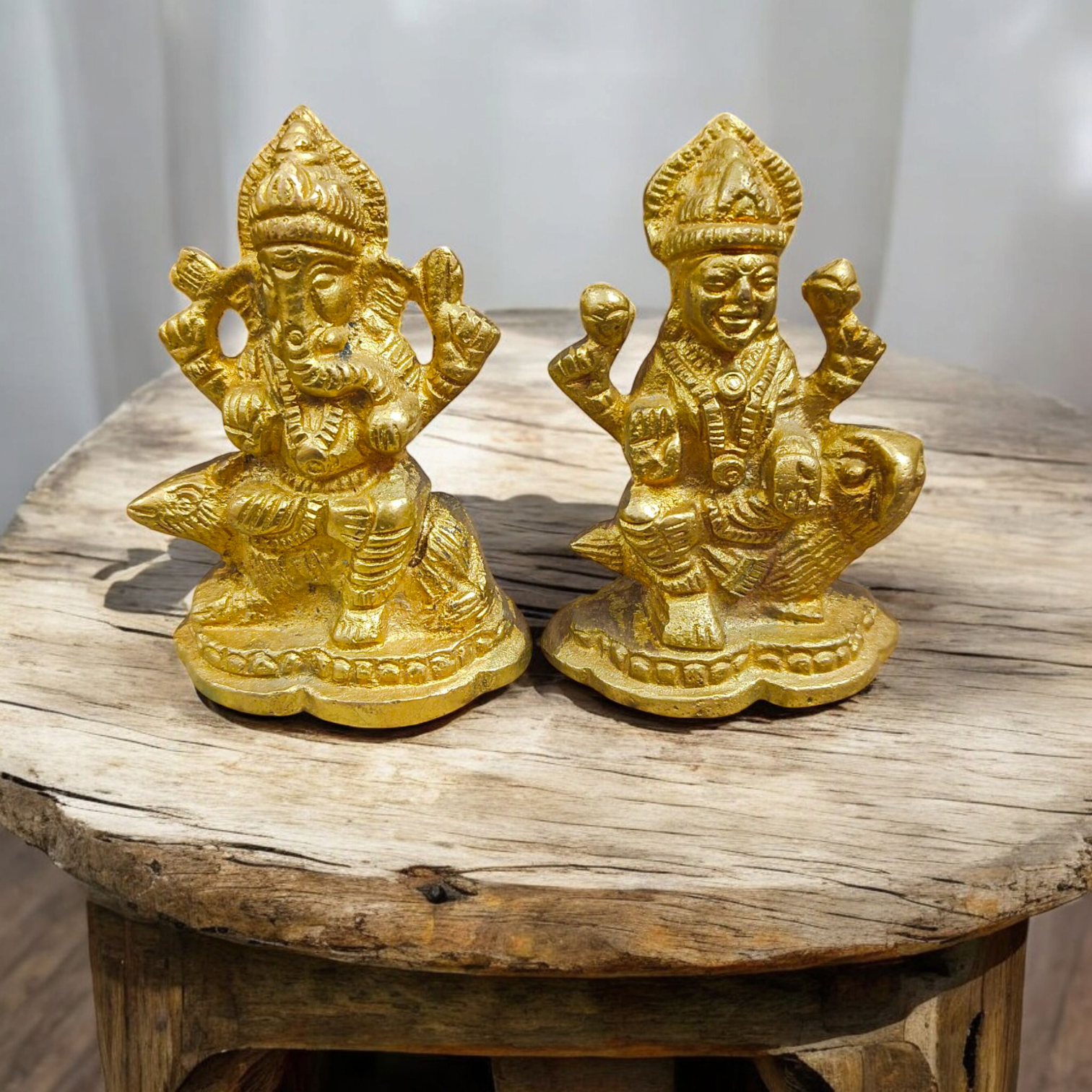 An intricately designed Lakshmi and Ganesh idol in brass, 100% gold plated, showcasing detailed craftsmanship. Perfect for puja or home decoration.

