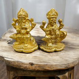 An intricately designed Lakshmi and Ganesh idol in brass, 100% gold plated, showcasing detailed craftsmanship. Perfect for puja or home decoration.

