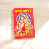 Bhajan Book in Hindi with colorful cover featuring Hindu deities and text mentioning 200+ bhajans and 15+ aartis