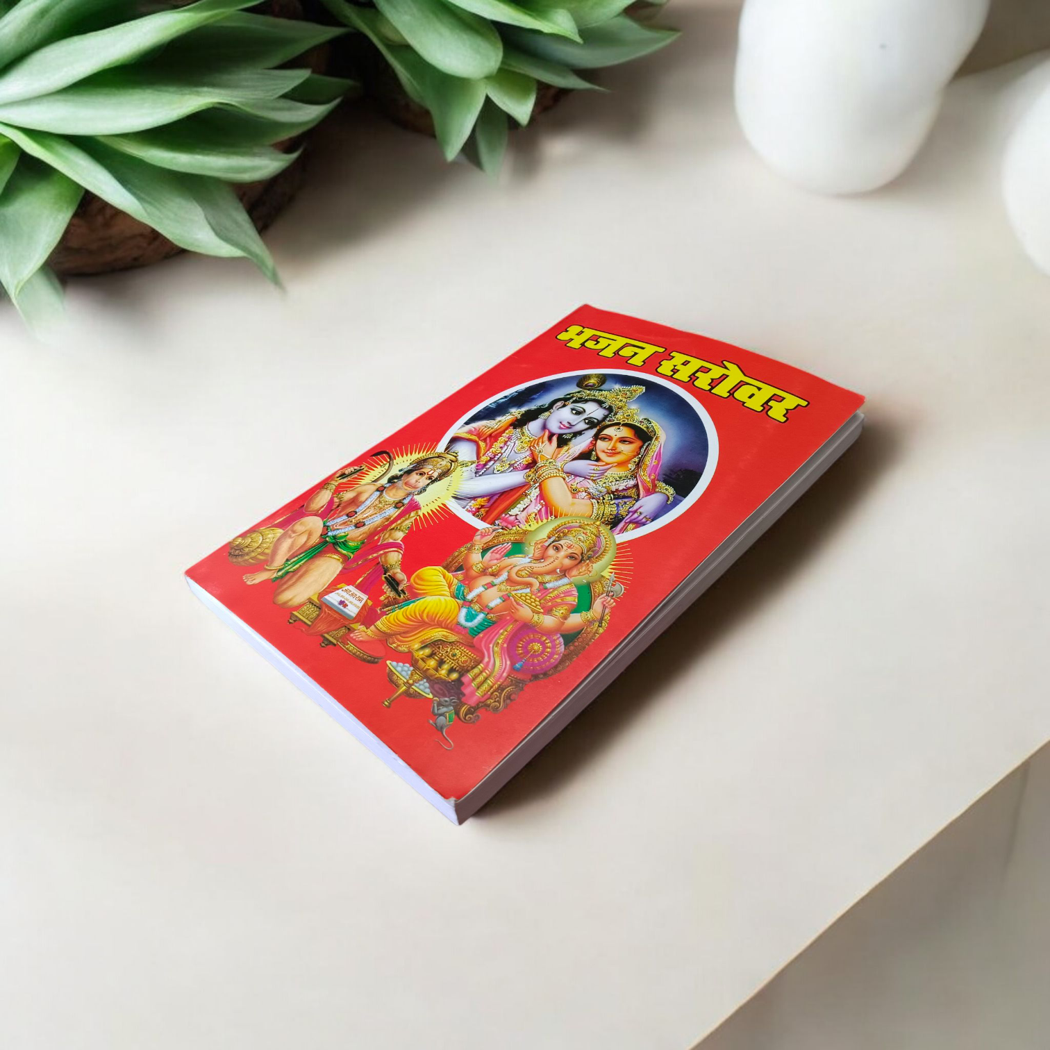Bhajan Book in Hindi with colorful cover featuring Hindu deities and text mentioning 200+ bhajans and 15+ aartis