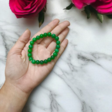 Close-up image of a Green Onyx Bracelet featuring polished 8mm beads on a stretchable band