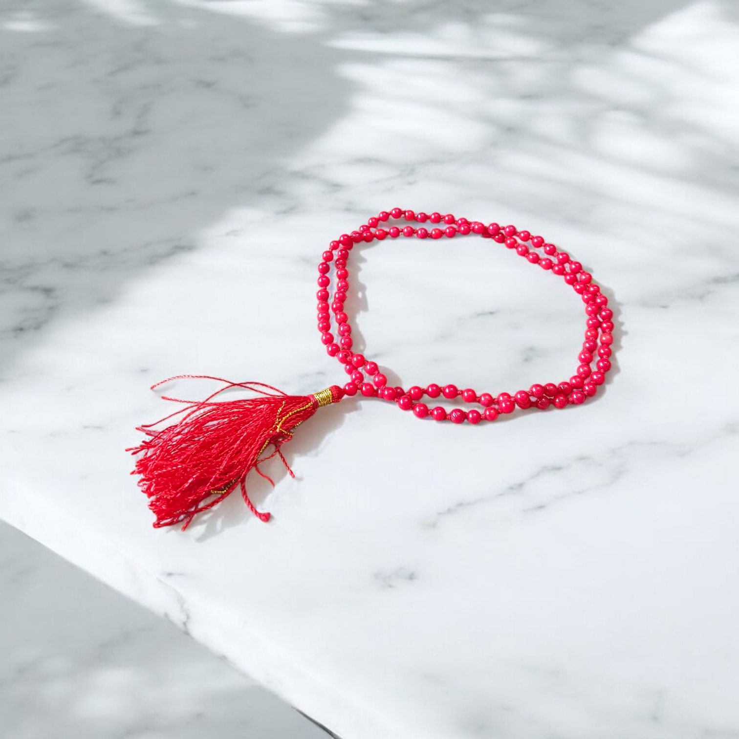Close-up image of a lab-certified Red Coral Mala with 4MM beads and 108+1 bead count, perfect for chanting and meditation