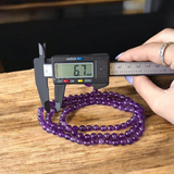 Close-up of Natural Amethyst Mala beads, 6MM size, showcasing purple hues and lab certificate tag