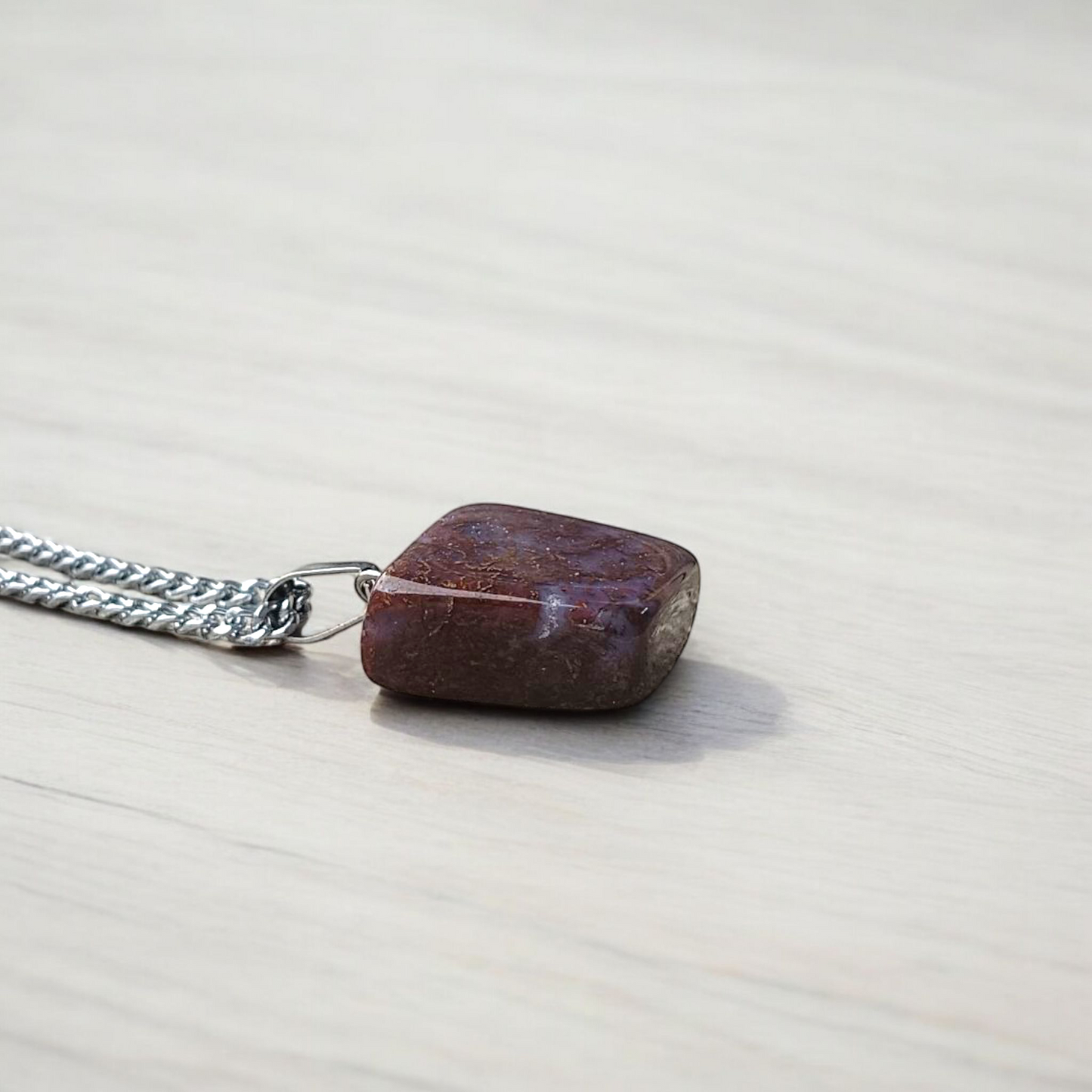 Close-up of lab-certified deep red Almandine Garnet pendant in elegant silver setting, ideal for daily wear and spiritual use