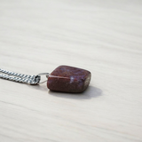 Close-up of lab-certified deep red Almandine Garnet pendant in elegant silver setting, ideal for daily wear and spiritual use