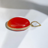 Close-up of the Original Orange Aventurine Pendant on a necklace, showing its vibrant orange hue and smooth, polished surface.