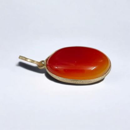 Close-up of the Original Orange Aventurine Pendant on a necklace, showing its vibrant orange hue and smooth, polished surface.