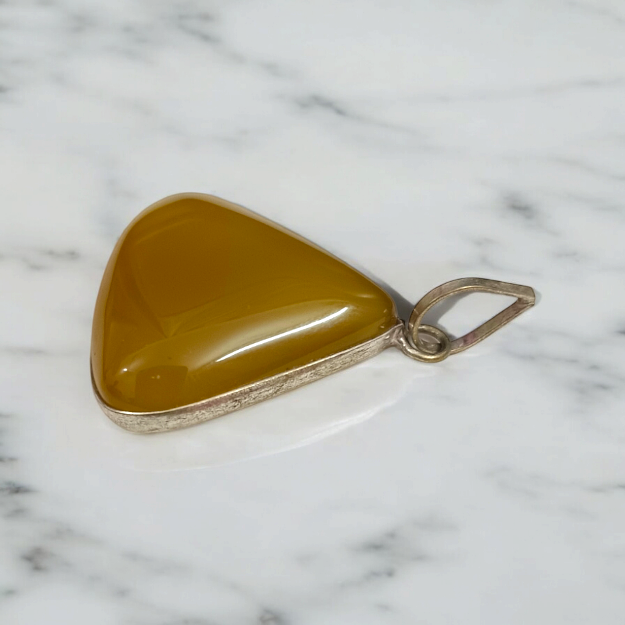 Close-up of the Original Yellow Aventurine Pendant, highlighting its smooth, vibrant yellow hue and polished surface on a necklace.