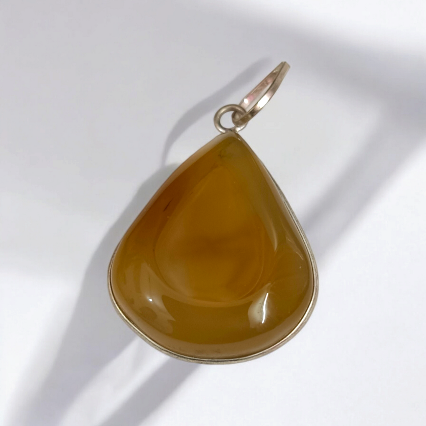 Close-up of the Original Yellow Aventurine Pendant, highlighting its smooth, vibrant yellow hue and polished surface on a necklace.