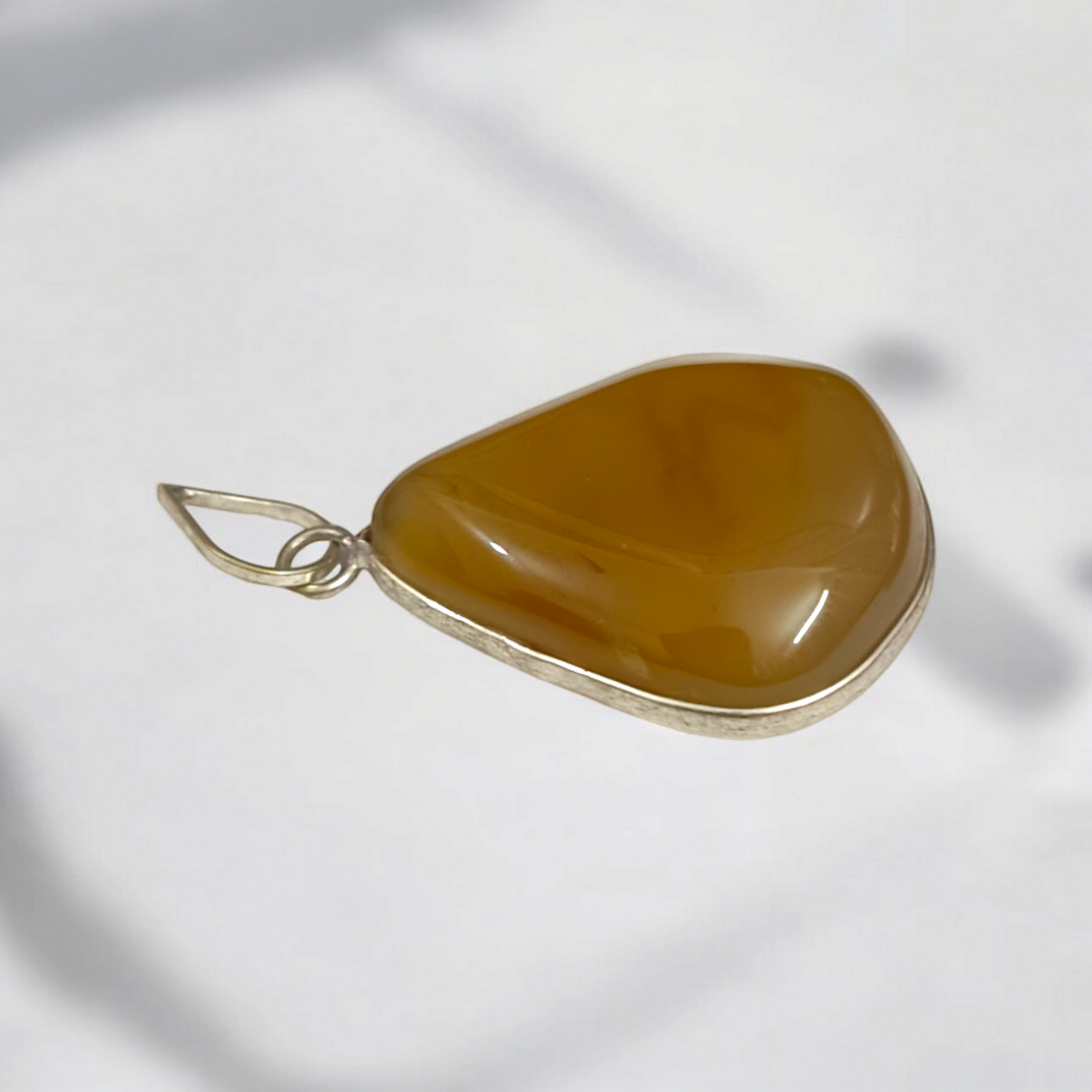 Close-up of the Original Yellow Aventurine Pendant, highlighting its smooth, vibrant yellow hue and polished surface on a necklace.