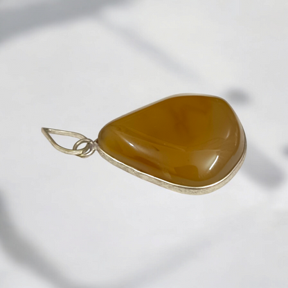 Close-up of the Original Yellow Aventurine Pendant, highlighting its smooth, vibrant yellow hue and polished surface on a necklace.