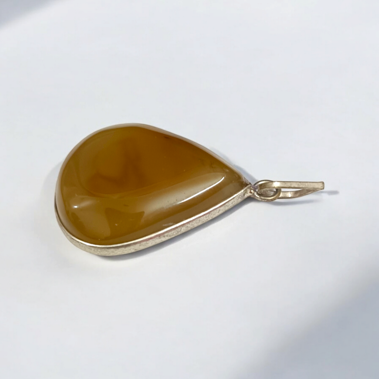 Close-up of the Original Yellow Aventurine Pendant, highlighting its smooth, vibrant yellow hue and polished surface on a necklace.