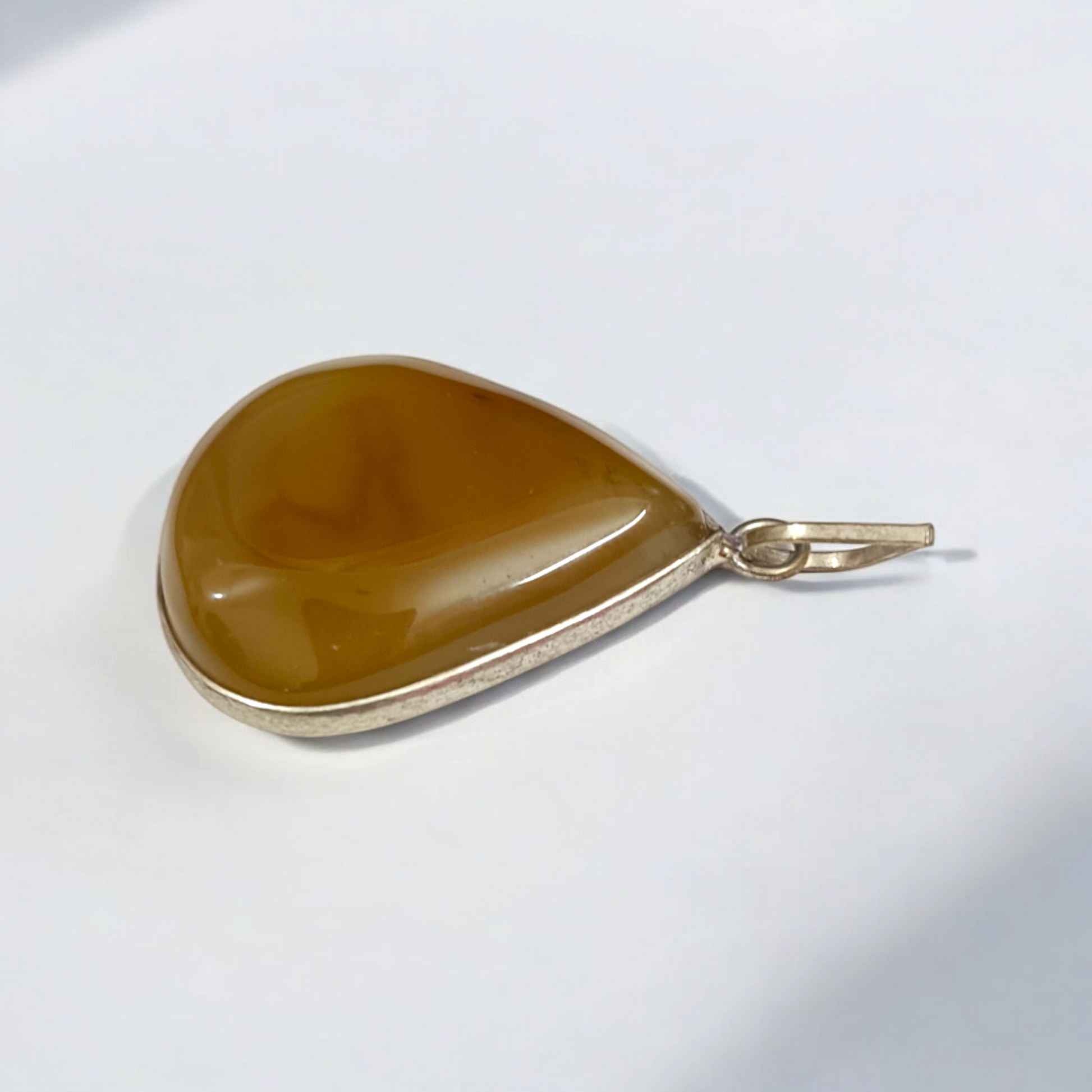 Close-up of the Original Yellow Aventurine Pendant, highlighting its smooth, vibrant yellow hue and polished surface on a necklace.