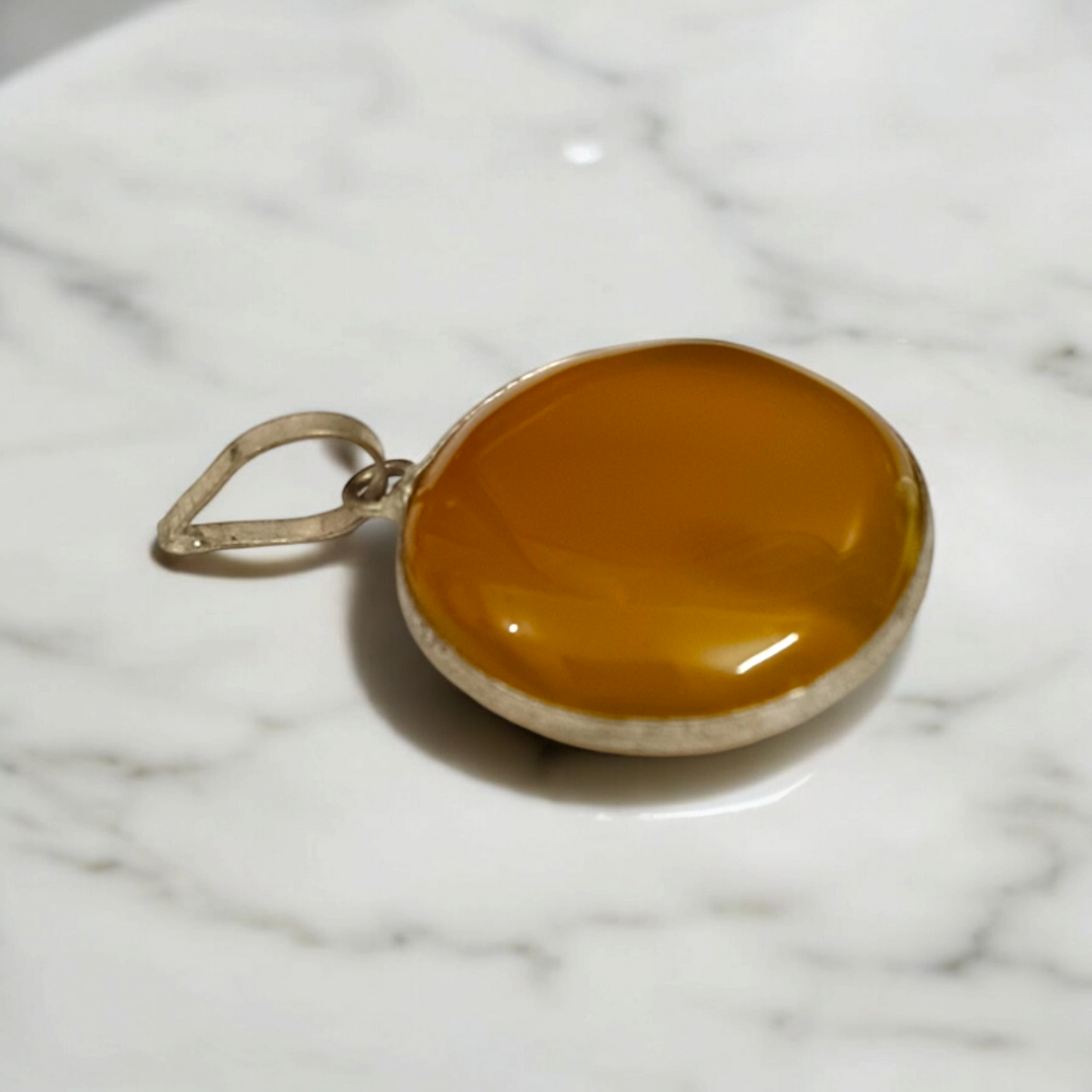 Close-up of the Original Yellow Aventurine Pendant, highlighting its smooth, vibrant yellow hue and polished surface on a necklace.