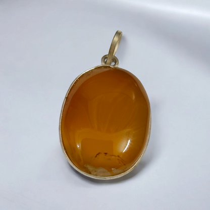 Close-up of the Original Yellow Aventurine Pendant, highlighting its smooth, vibrant yellow hue and polished surface on a necklace.