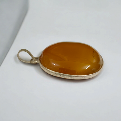 Close-up of the Original Yellow Aventurine Pendant, highlighting its smooth, vibrant yellow hue and polished surface on a necklace.