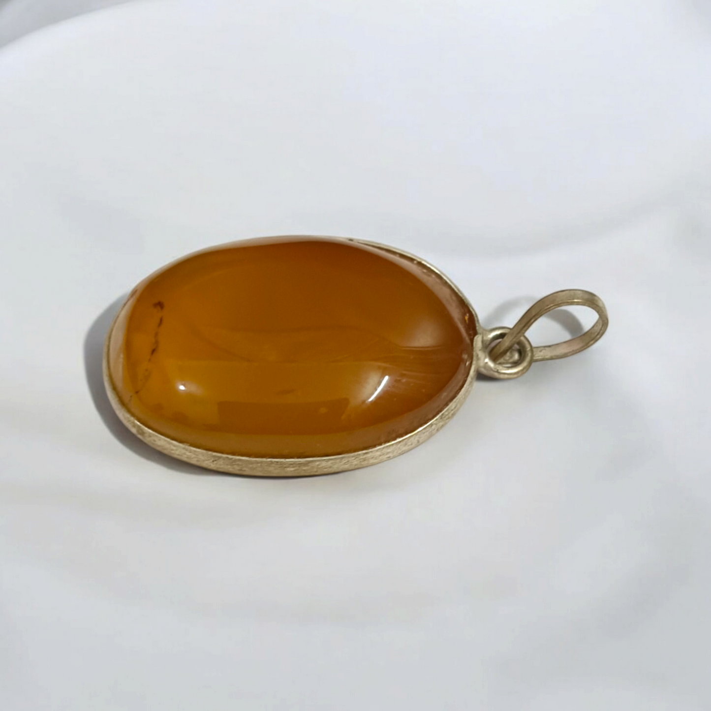 Close-up of the Original Yellow Aventurine Pendant, highlighting its smooth, vibrant yellow hue and polished surface on a necklace.