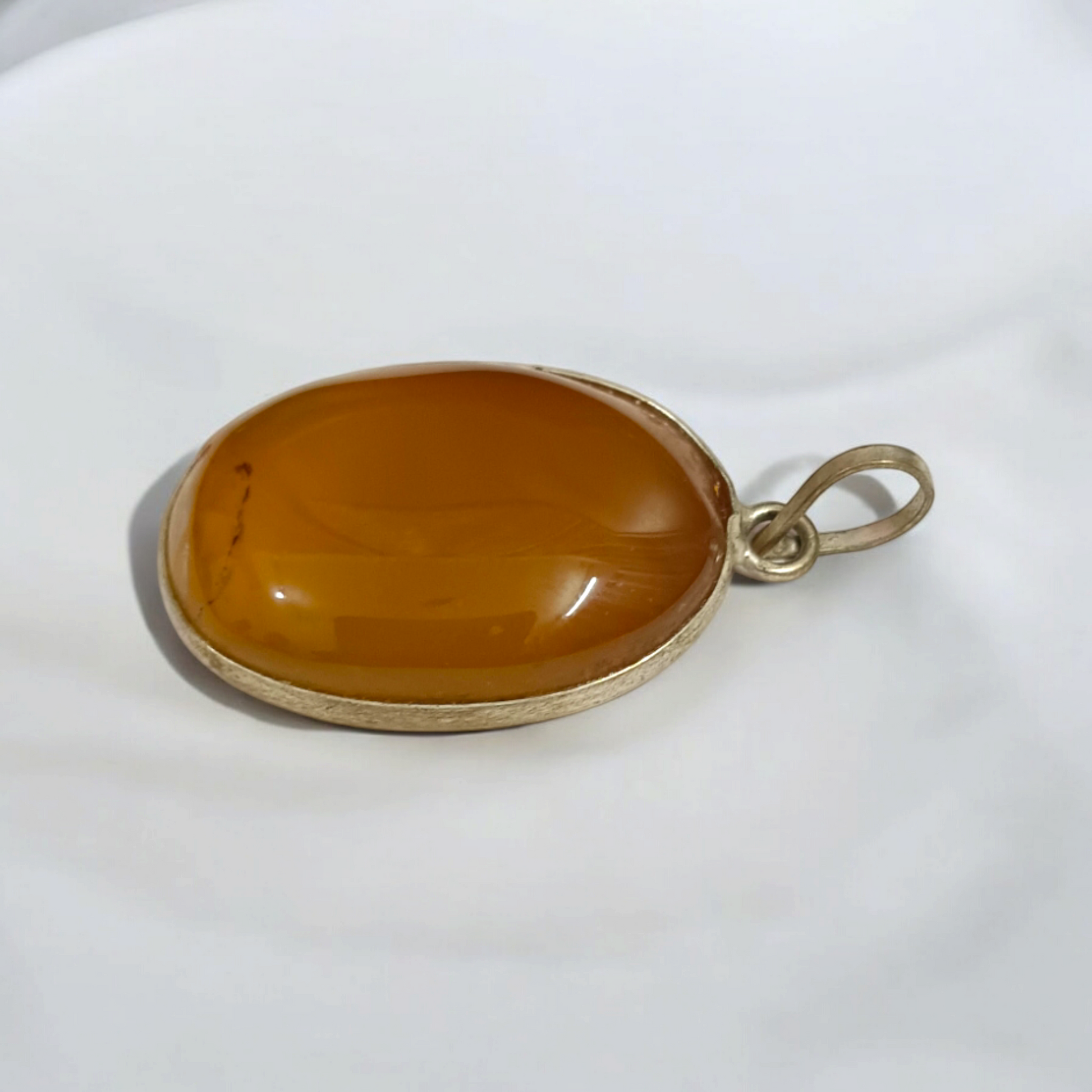 Close-up of the Original Yellow Aventurine Pendant, highlighting its smooth, vibrant yellow hue and polished surface on a necklace.
