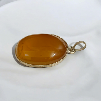 Close-up of the Original Yellow Aventurine Pendant, highlighting its smooth, vibrant yellow hue and polished surface on a necklace.