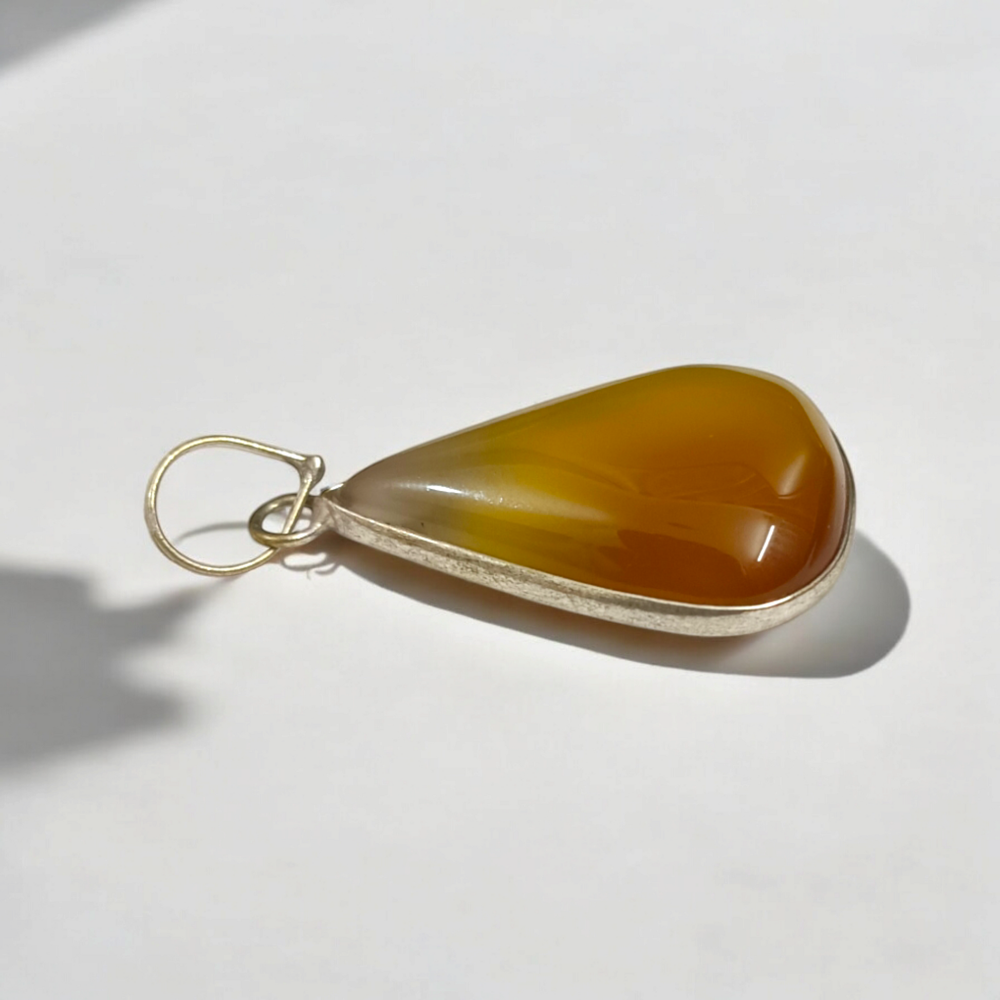 Close-up of the Original Yellow Aventurine Pendant, highlighting its smooth, vibrant yellow hue and polished surface on a necklace.