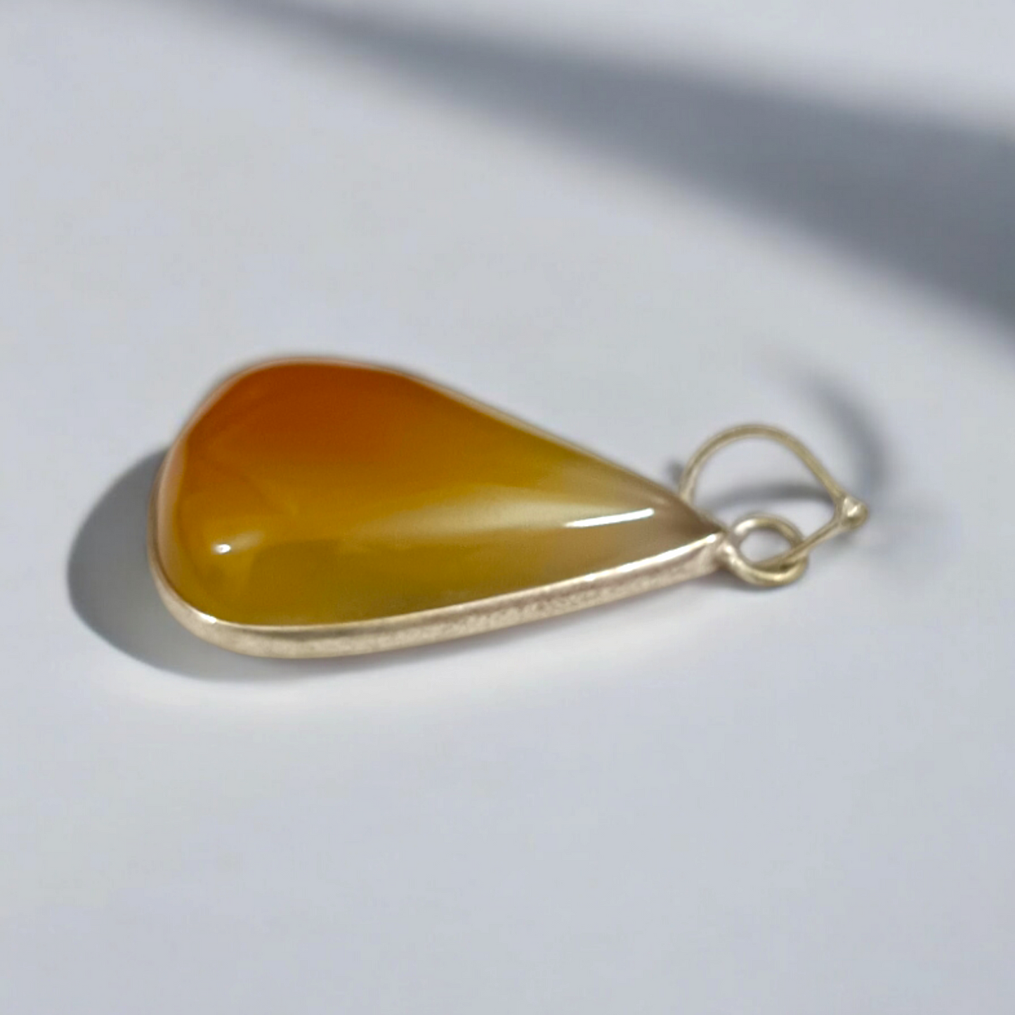 Close-up of the Original Yellow Aventurine Pendant, highlighting its smooth, vibrant yellow hue and polished surface on a necklace.