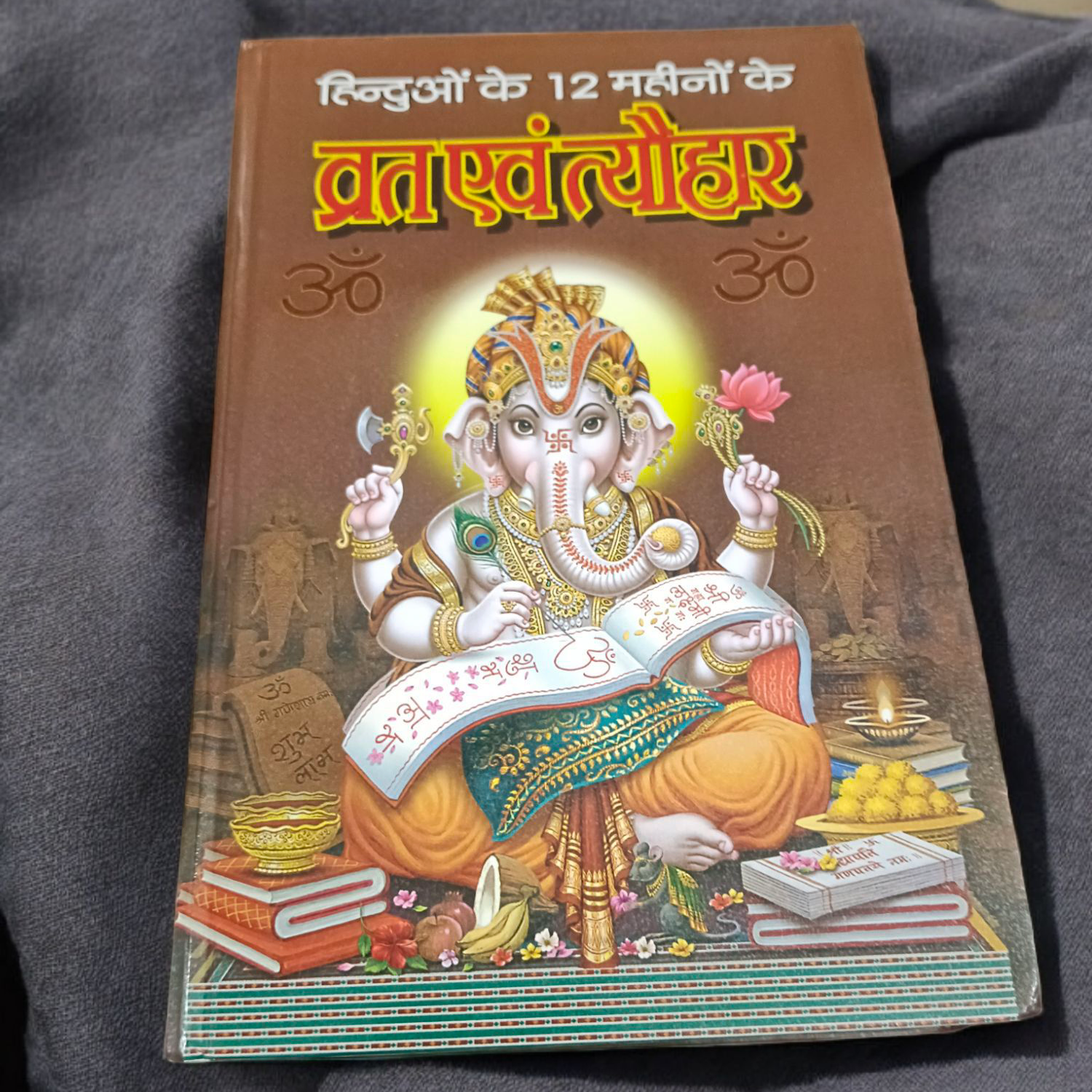 Description of the image: The cover of Barah Mahino Ke Sampooran Vart Aur Tyohar | Hindi Book, featuring vibrant images of various Hindu festivals and symbols.