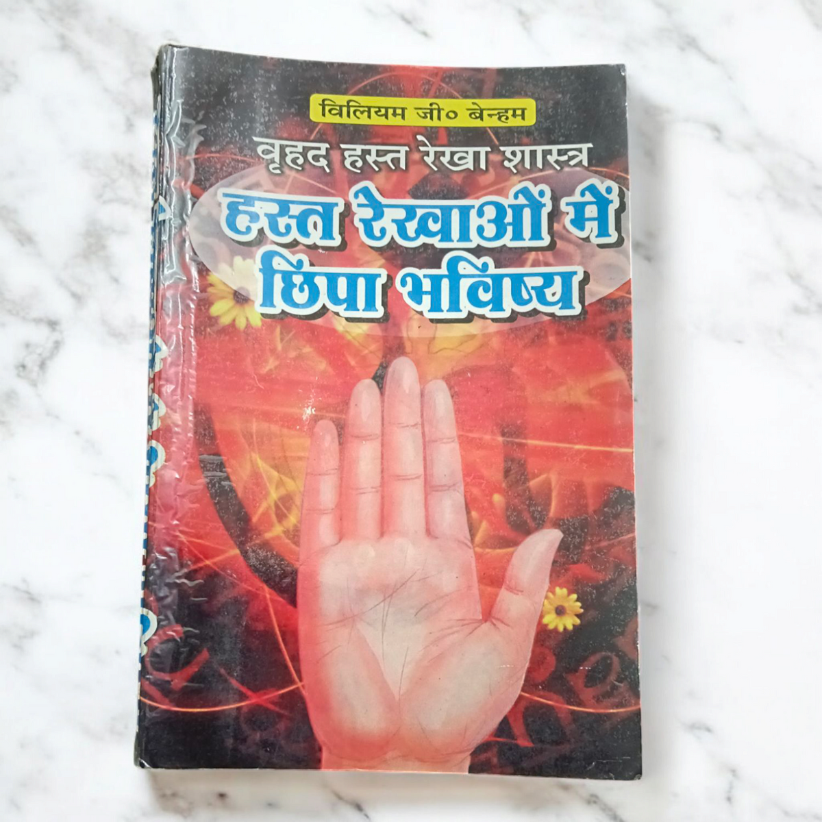 Description of the image: The cover of Hast Rekha Me Chipa Bhavisya Palmistry Specialist | Hindi Book, featuring an image of hands with visible palm lines and astrological symbols