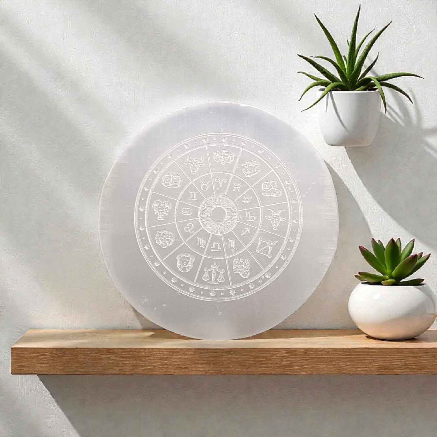 Engraved selenite crystal charging plate with zodiac signs, used for cleansing and recharging crystals, meditation, pooja, and spiritual home décor