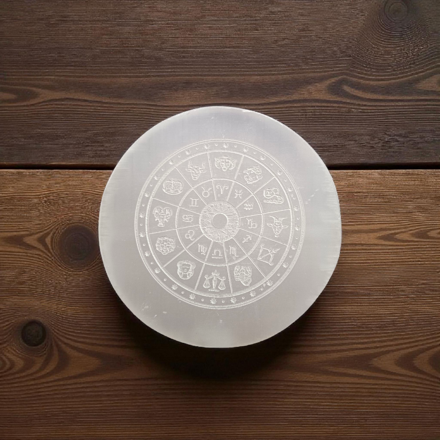 Engraved selenite crystal charging plate with zodiac signs, used for cleansing and recharging crystals, meditation, pooja, and spiritual home décor