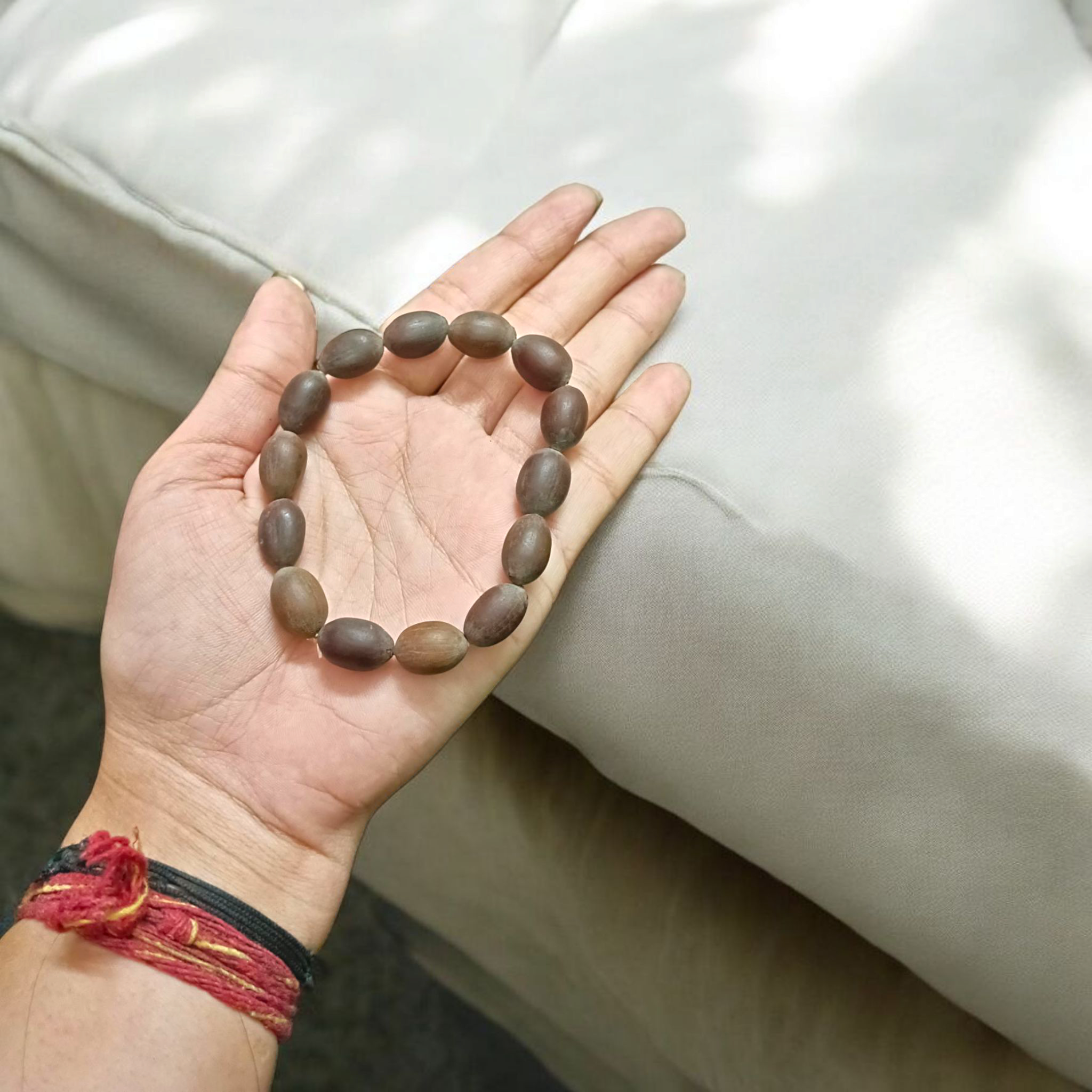 Image of Natural Kamal Gutta Bracelet made from 100% Original Lotus Seeds with Lab Certificate shown on a wrist for spiritual use