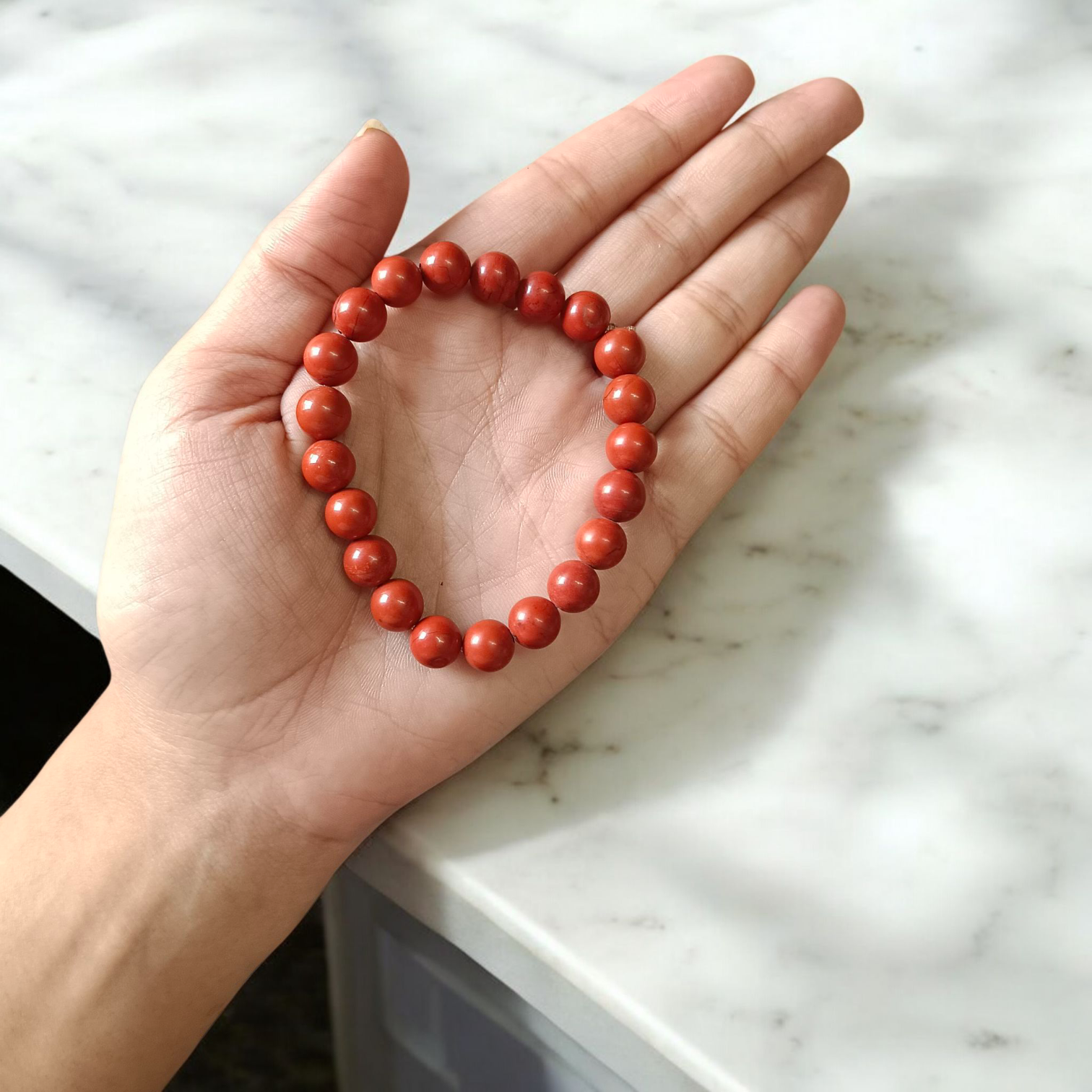 Image of a Natural Red Jasper Bracelet with 8mm polished beads, stretchable cord, and lab-certified gemstone design