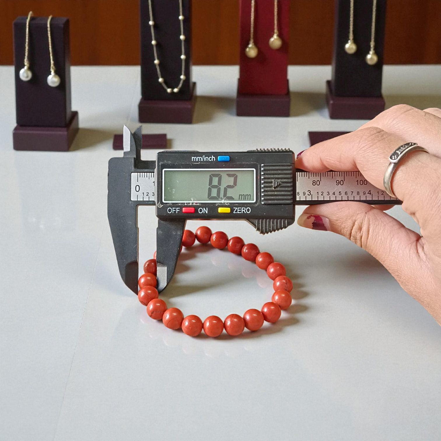 Image of a Natural Red Jasper Bracelet with 8mm polished beads, stretchable cord, and lab-certified gemstone design