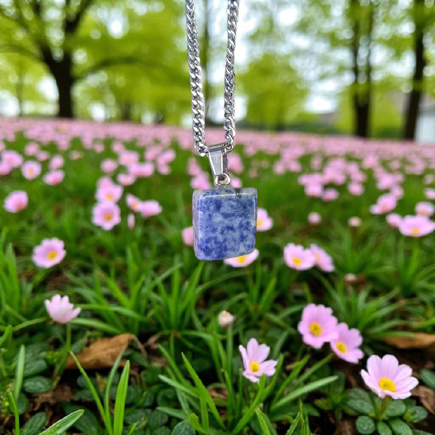Image of a deep blue Lapis Lazuli Pendant with shimmering golden flecks, attached to a white metal chain – ideal for daily wear and spiritual benefits