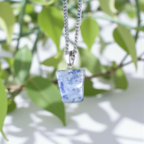 Image of a deep blue Lapis Lazuli Pendant with shimmering golden flecks, attached to a white metal chain – ideal for daily wear and spiritual benefits