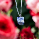 Image of a deep blue Lapis Lazuli Pendant with shimmering golden flecks, attached to a white metal chain – ideal for daily wear and spiritual benefits