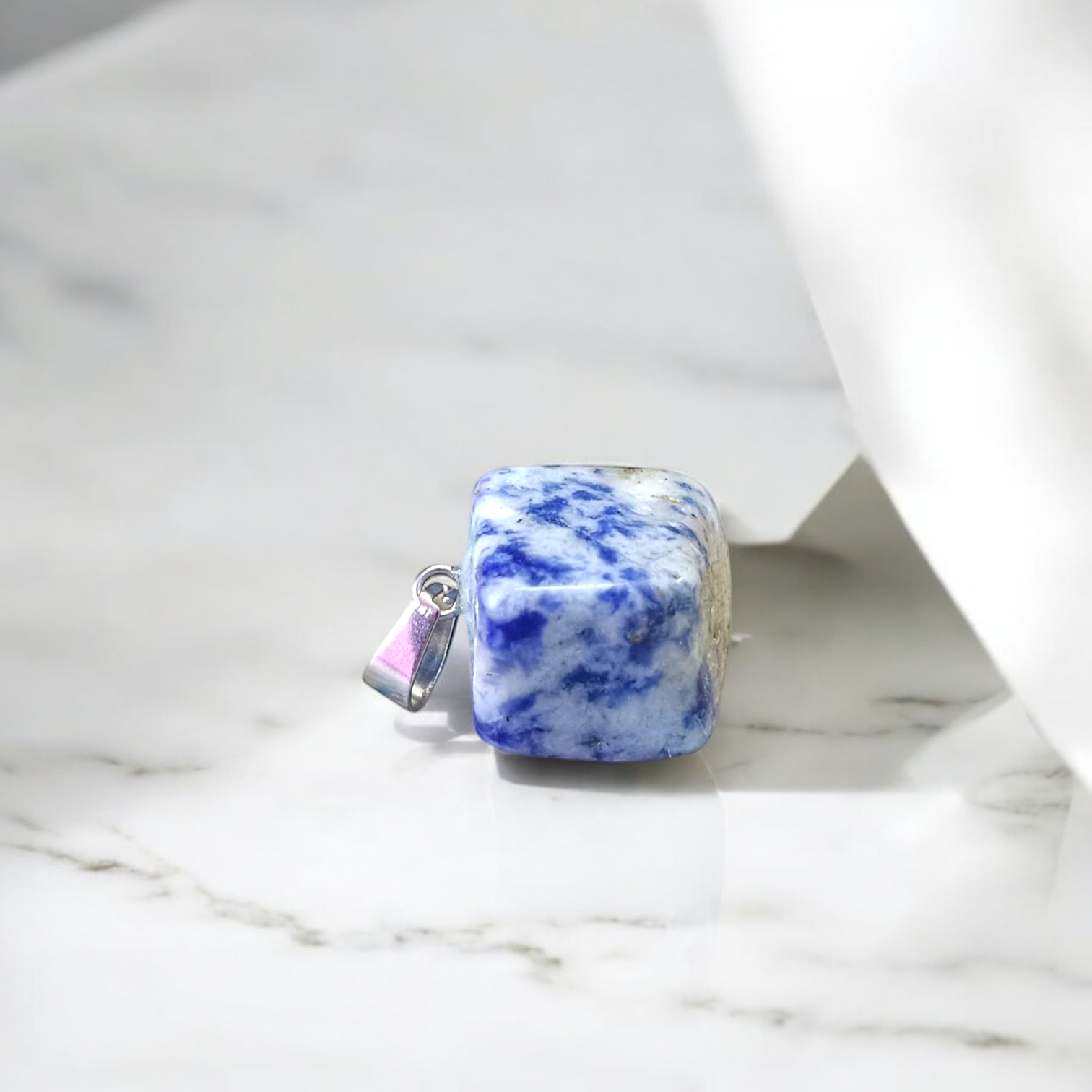 Image of a deep blue Lapis Lazuli Pendant with shimmering golden flecks, attached to a white metal chain – ideal for daily wear and spiritual benefits