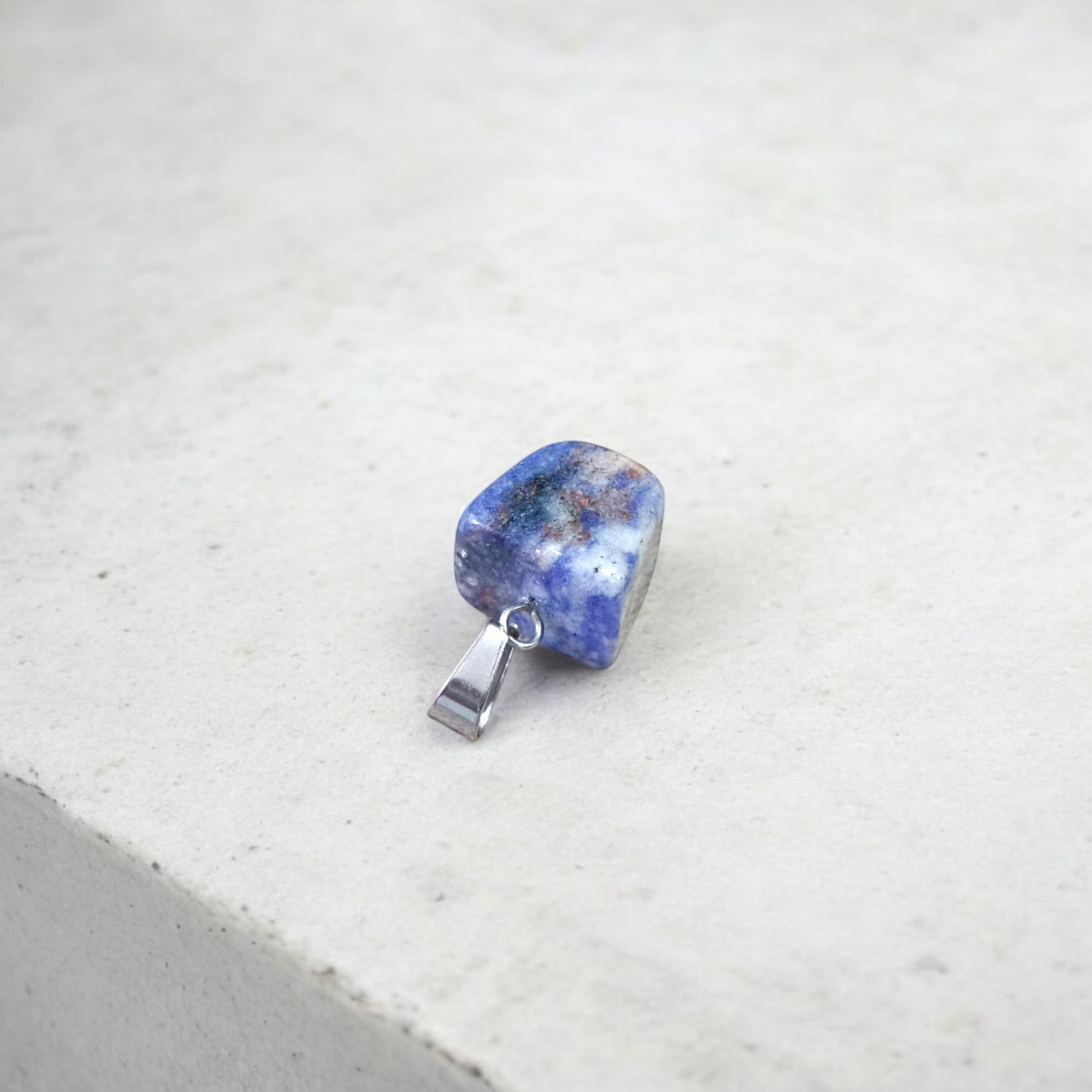 Image of a deep blue Lapis Lazuli Pendant with shimmering golden flecks, attached to a white metal chain – ideal for daily wear and spiritual benefits