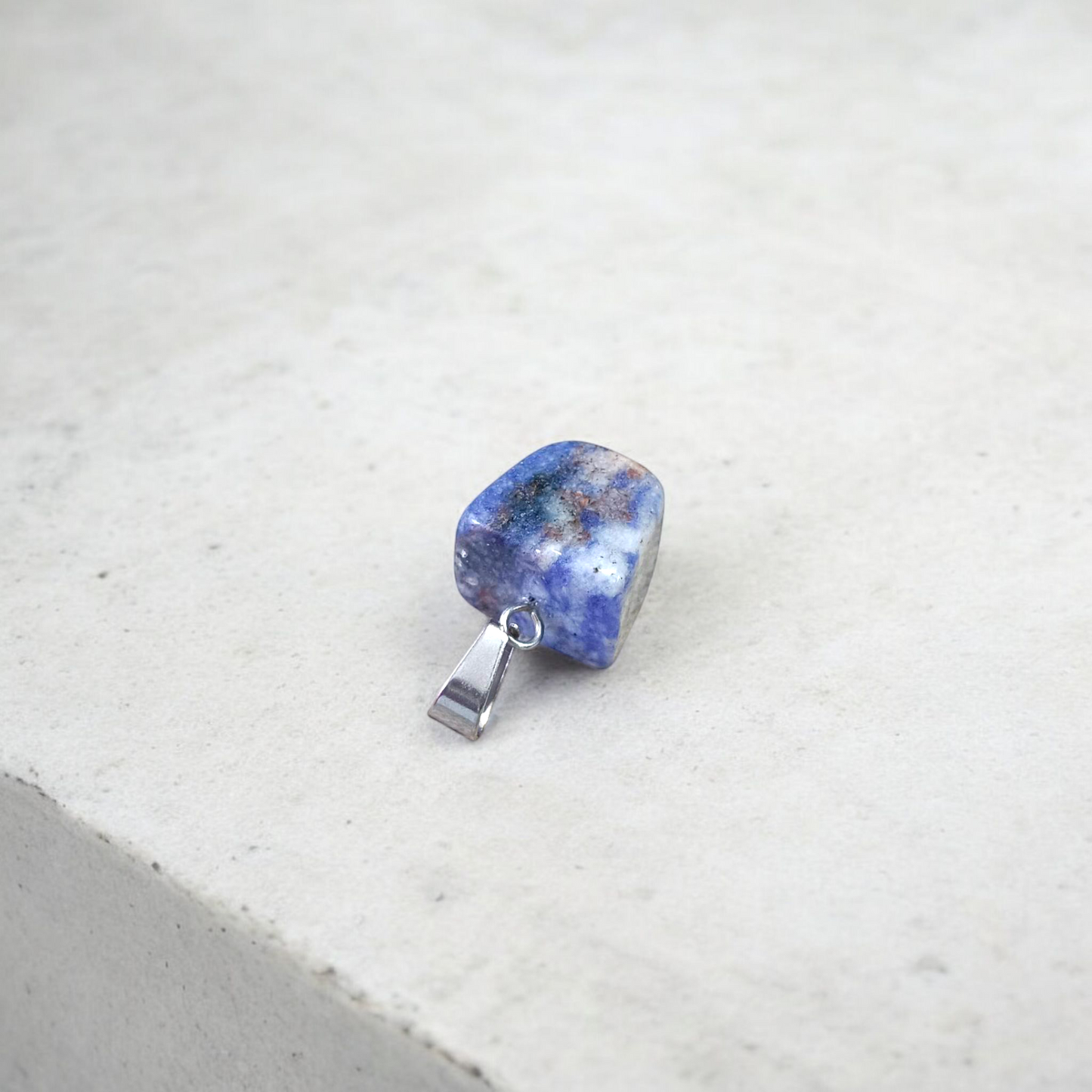 Image of a deep blue Lapis Lazuli Pendant with shimmering golden flecks, attached to a white metal chain – ideal for daily wear and spiritual benefits