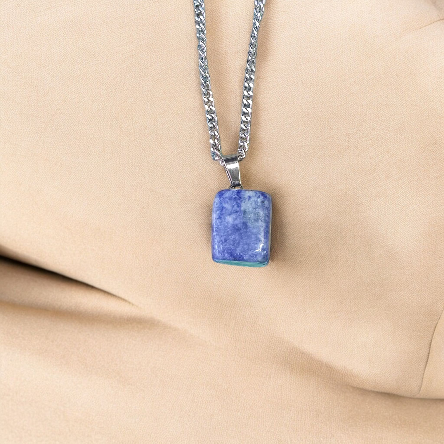Image of a deep blue Lapis Lazuli Pendant with shimmering golden flecks, attached to a white metal chain – ideal for daily wear and spiritual benefits