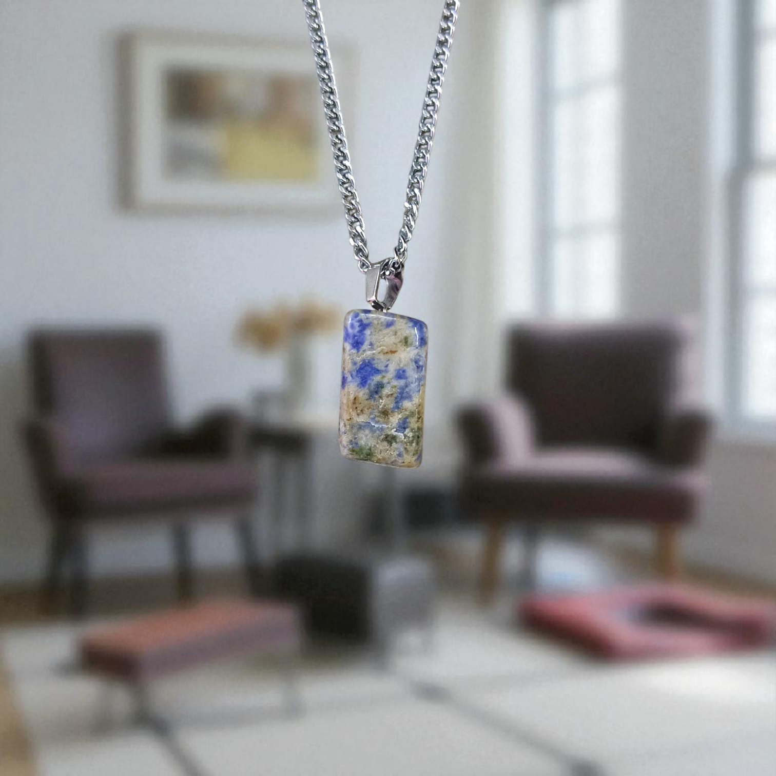 Image of a deep blue Lapis Lazuli Pendant with shimmering golden flecks, attached to a white metal chain – ideal for daily wear and spiritual benefits