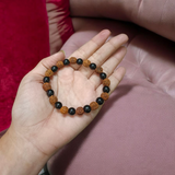 Natural Agate and 5 Mukhi Rudraksha Bracelet with 8mm black and brown beads on stretchable thread, lab certified, displayed on a natural stone background
