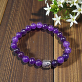 Natural Amethyst Bracelet with polished purple beads, stretchable design, placed on a neutral background