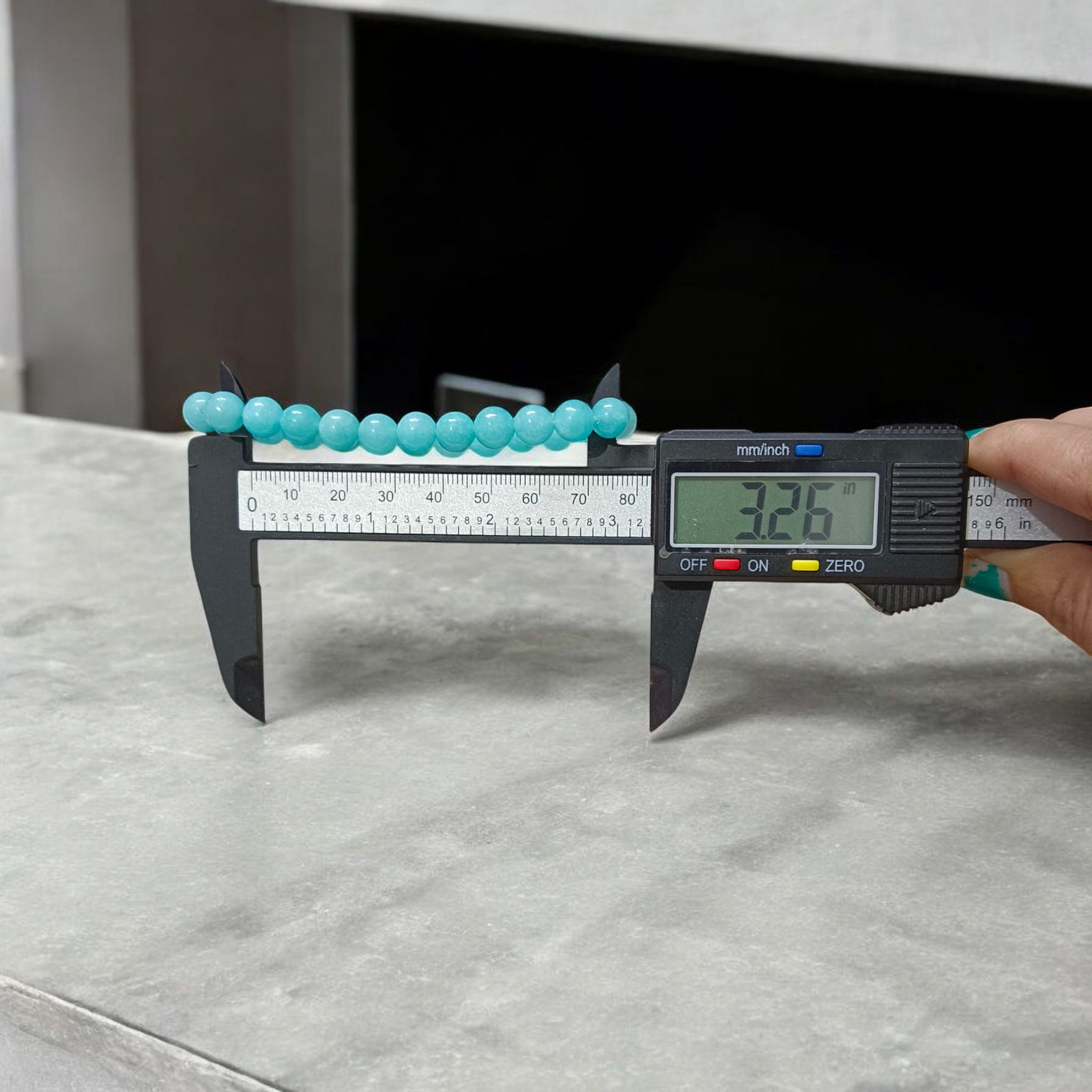 Natural Blue Chalcedony Bracelet made with 8mm smooth round stretchable beads, lab certified, placed on a natural stone background