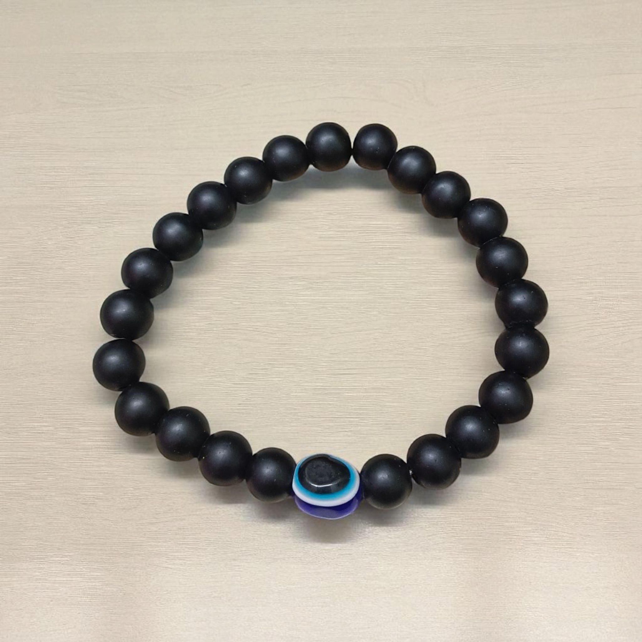 Natural Karungali (Ebony Wood) Bracelet with 8mm round beads and a central Evil Eye bead, stretchable and lab certified, displayed on a neutral background