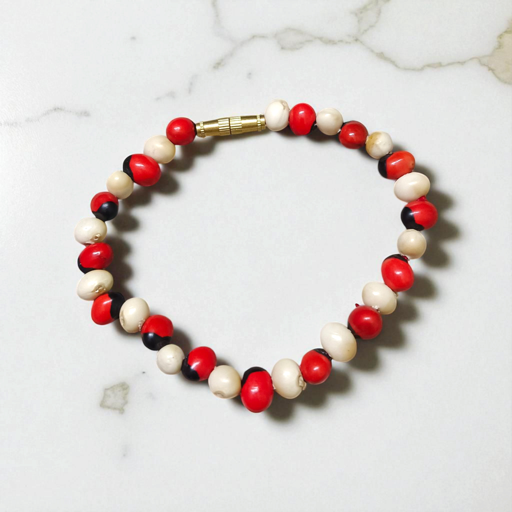 Natural Red and White Gunja bracelet with 5mm lab certified beads on stretchable cord, displayed on a neutral background