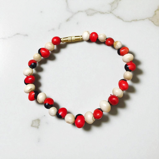 Natural Red and White Gunja bracelet with 5mm lab certified beads on stretchable cord, displayed on a neutral background