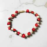Natural Red and White Gunja bracelet with 5mm lab certified beads on stretchable cord, displayed on a neutral background